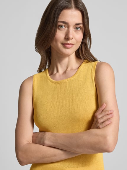 Frauenmodel trägt Regular Fit T-Shirt aus Viskose-Mix von Selected Femme, gelb, unifarben, Strick, Rundhals, ohne Ärmel, Nahaufnahme Oberkörper.