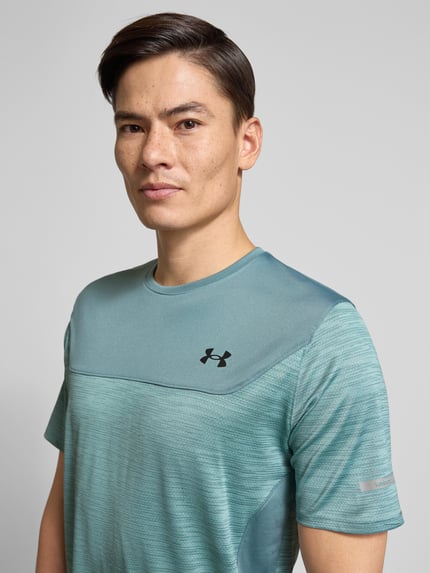 Männermodel trägt Funktionsshirt mit Logo und Rundhalsausschnitt von Under Armour im Material-Mix mit Stretch-Anteil, Regular Fit, Nahaufnahme Oberkörper. Rückenlänge bei Größe M: 71 cm.