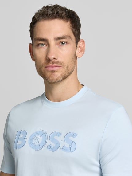 Männermodel trägt Regular Fit T-Shirt aus reiner Baumwolle Modell 'C-THOMPSON 89' von BOSS, Optik: Unifarben, Label-Print, Rundhals, Kurzarm, Jersey, Nahaufnahme Oberkörper.
