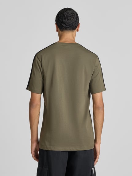 Męski model nosi Regular Fit T-Shirt aus reiner Baumwolle Modell 'M 3S SJ LC T' von adidas Sportswear, oliwkowozielony, pełny widok z tyłu.