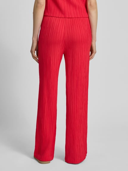Frauenmodel trägt Hose mit Strukturmuster Modell 'Grsvalse' von FREE/QUENT in Rot, weites Bein, elastischer Bund, Ganzkörperansicht Rückansicht.