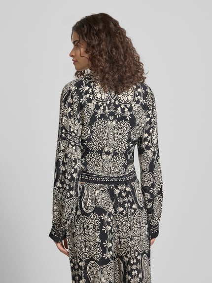 Frauenmodel trägt Shaped Fit Bluse aus reiner Viskose Modell 'LEMZA' von Only mit florales-Allover-Muster, Wickeloptik, Ganzkörperansicht Rückansicht.