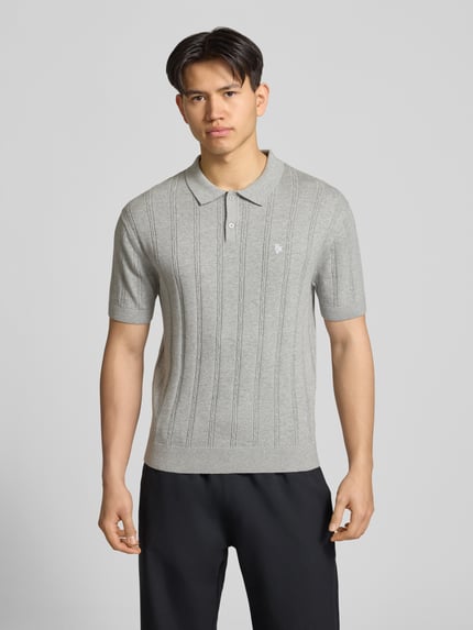 Männermodel trägt Slim Fit Strick-Poloshirt mit Label-Stitching von REVIEW in Grau mit Zopfmuster, Reine Baumwolle, Knopfleiste, Ganzkörperansicht von vorne.