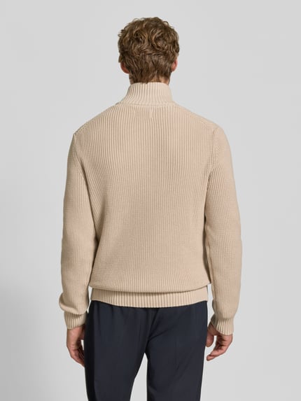 Männermodel trägt Slim Fit Strickpullover aus reiner Baumwolle mit Troyer-Kragen von MCNEAL in Beige, gerippte Abschlüsse, Ganzkörperansicht Rückansicht
