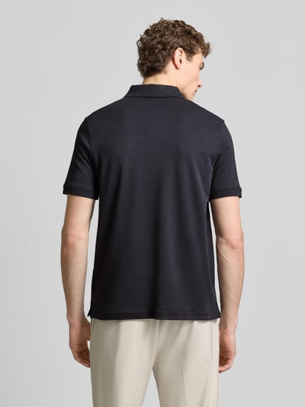 Männermodel trägt Regular Fit Poloshirt mit Logo-Stitching von Fynch-Hatton in Schwarz, reine Baumwolle, Rückenansicht, Ganzkörperansicht.