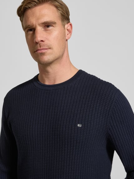 Männermodel draagt Strickpullover mit Label-Detail van Christian Berg Men, donkerblauw, katoen, ronde hals, Nahaufnahme bovenlichaam.