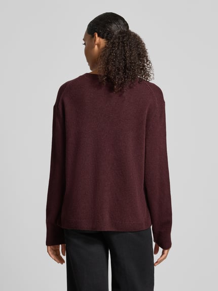 Frauenmodel trägt Loose Fit Pullover aus reiner Wolle von Marc O'Polo in Dunkelrot, glatte Textur, Ganzkörperansicht Rückansicht. Damen Pullover von Marc O'Polo.