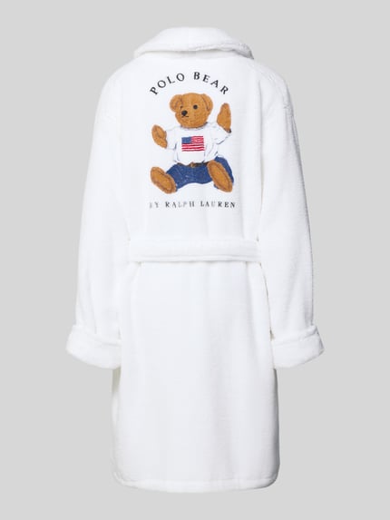 Frauenmodel trägt Comfort Fit Bademantel aus reiner Baumwolle Modell 'ICONIC BEAR' von Polo Ralph Lauren in Weiß, Frottee, Logo-Stitching, Schalkragen, Taillengürtel, Rückansicht, Ganzkörperansicht.