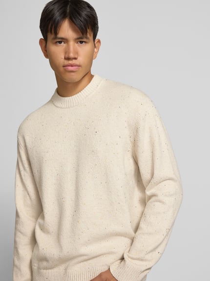Männermodel trägt Regular Fit Strickpullover mit Rundhalsausschnitt van JACK & JONES, Materiaalmix met katoen, regular fit, ronde hals, ribboorden, met lange mouwen, logopatch, geribde bies, ruglengte maat M 66 cm, mouwlengte maat M 64 cm, lichte kleur, gespikkelde textuur, Nahaufnahme Oberkörper.