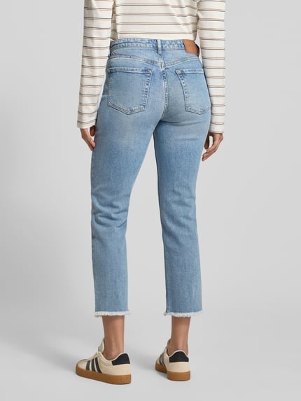 Frauenmodel trägt Straight Leg Jeans aus Baumwoll-Mix Modell 'LINDE' von Marc O'Polo in Hellblau, Cropped-Länge, Fransen, 5-Pocket, Ganzkörperansicht Rückansicht.