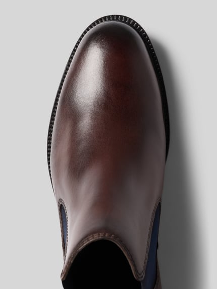 Produktfoto, Chelsea Boots aus echtem Leder Modell 'Bonifacio' von bugatti in Braun mit abgerundeter Passform, Detailansicht, leicht profilierte Sohle, Logo-Detail