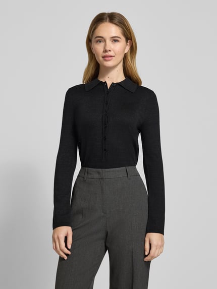 Vrouwenmodel draagt Slim Fit Langarmshirt aus Lyocell-Baumwoll-Mix Modell 'FLURA LUREX' van Selected Femme, zwart, unikleurige glanzende gebreide stof, polokraag, geribde boorden, korte knoopsluiting, label stitching detail, Ganzkörperaanzicht van voren.