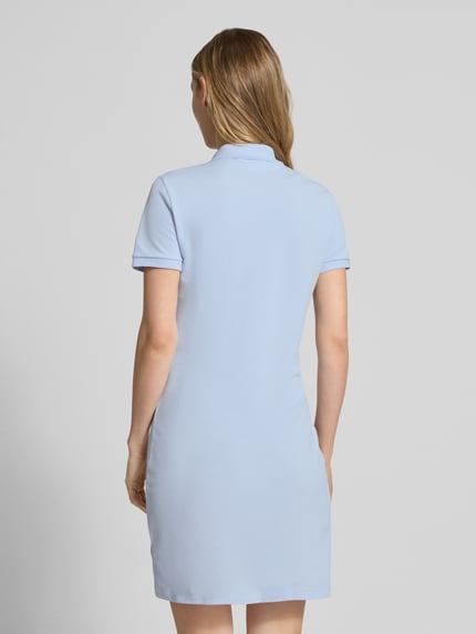 Frauenmodel trägt Slim Fit Polokleid aus Baumwoll-Mix von Lacoste in Hellblau mit kurzem Arm und Logo-Stitching, Ganzkörperansicht Rückansicht.