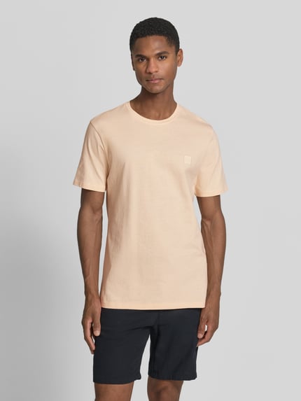 Męski model nosi Regular Fit T-Shirt aus reiner Baumwolle Modell 'TALES' von BOSS Orange, efekt: jednolity kolor, naszywka z logo, okrągły dekolt, krótki rękaw, bawełna, Ganzkörperansicht von vorne.