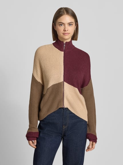 Frauenmodel trägt Jacke in Strick-Optik Modell 'Charlie' von NOISY MAY®, beige, braun und bordeaux, lockere Passform, Ganzkörperansicht von vorne.