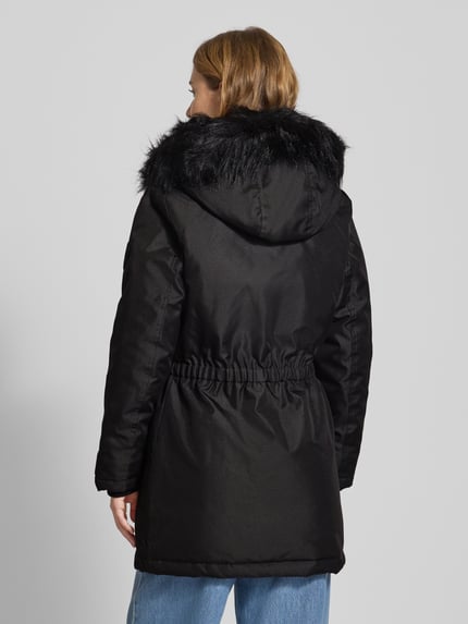 Frauenmodel trägt Shaped Fit Parka mit Label Patch Modell 'IRIS' von Only, Optik: Unifarben, Regular-Fit, Kapuze mit Webpelzbesatz, Langarm, Storm Cuffs, seitliche Pattentaschen, Brustpattentaschen, verdeckter Reißverschluss mit einreihiger Knopfleiste, Ganzkörperansicht Rückansicht.