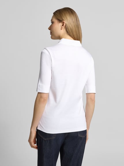 Frauenmodel trägt Slim Fit Poloshirt mit Knopfleiste und 1/2-Arm von Christian Berg Woman, Reine Baumwolle, Rückenlänge 61 cm, Ganzkörperansicht Rückansicht.