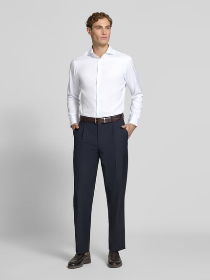 Männermodel trägt Slim Fit Business-Hemd aus reiner Baumwolle von Christian Berg Men, weiß mit Haikragen, Ganzkörperansicht von vorne. Kontext: Langärmeliges Herren Business-Hemd, durchgehende Knopfleiste, Rückenlänge 79 cm, Schulterbreite 44 cm, Ärmellänge 67 cm.