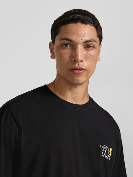 Männermodel trägt T-Shirt mit Motiv-Print Modell 'VINTAGE CARTOON' von Jack & Jones aus reiner Baumwolle, Regular-Fit, Rundhalsausschnitt, Nahaufnahme Oberkörper.
