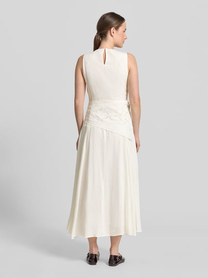 Frauenmodel trägt Midikleid aus Viskose-Mix mit Spitzenbesatz von Mango, cremefarben, taillierte Passform, Rückenlänge 126 cm, Ganzkörperansicht Rückansicht.