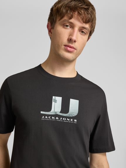 Männermodel trägt Herren T-Shirt im 3er-Pack mit Statement-Print Modell 'DUST' von Jack & Jones aus reiner Baumwolle, Nahaufnahme Oberkörper.