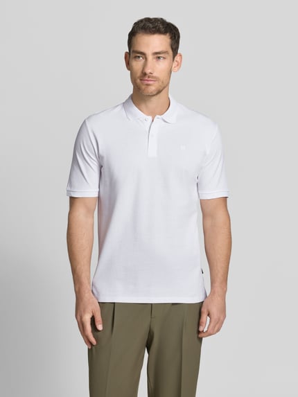 Mężczyznę model nosi Slim Fit Poloshirt mit Stitching von Jack & Jones Premium z bawełny, krój slim fit, haft, listwa guzikowa, długość tyłu 70 cm w rozmiarze M, widok całej sylwetki z przodu.