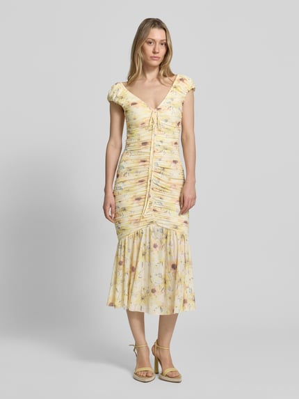 Vrouwenmodel draagt Midikleid met Drapierungen und V-Ausschnitt van Little Mistress, materiaalmix met stretch, nauw aansluitend model, ruglengte maat 36 120 cm, lichtgeel met bloemmotief, plooien, midi-lengte, hele lichaamsaanzicht van voren.