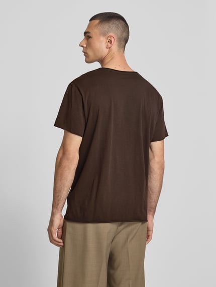Männermodel trägt T-Shirt mit Rundhalsausschnitt von Filippa K in Braun, reine Baumwolle, Regular Fit, Rückansicht Ganzkörperansicht.