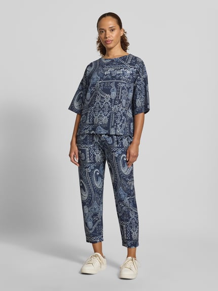 Frauenmodel trägt Regular Fit Hose aus Viskose-Mix von Christian Berg Woman mit Allover-Paisley-Print und elastischem Bund in Blau, Ganzkörperansicht von vorne.