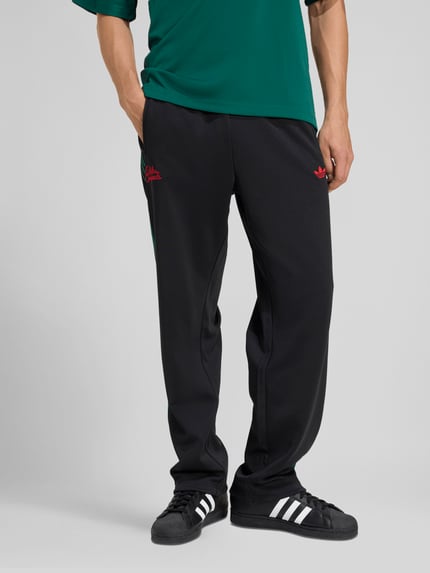 Männermodel trägt Regular Fit Sweatpants mit Baumwoll-Anteil von adidas Originals, Optik: Unifarben, mit Logo-Stitching und Galonstreifen, Passform: Regular-Fit, Bundabschluss: elastisch, Materialverarbeitung: Sweat, Ganzkörperansicht von vorne.