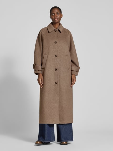 Frauenmodel trägt Mantel aus Leinen-Mix mit Stehkragen Modell 'Keaton' von Neo Noir in Braun, Regular Fit, Knopfleiste, Eingrifftaschen, Ganzkörperansicht von vorne. Rückenlänge 123 cm, Schulterbreite 38 cm, Brustweite 53 cm, Ärmellänge 59 cm.