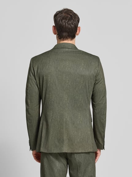 Männermodel trägt Regular Fit Sakko mit Viskose-Anteil Modell 'Calvin' von CG - Club of Gents in grün mit 2-Knopfleiste, Pattentaschen, Brusttasche, Logo-Detail, Elastischer-Material-Mix, Ganzkörperansicht Rückansicht.