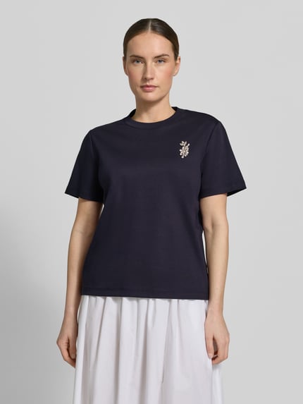 Frauenmodel trägt Damen T-Shirt mit Ziersteinbesatz von Comma, dunkelblau, Reine Baumwolle, Regular-Fit, Rundhalsausschnitt, Rückenlänge 58 cm, Ganzkörperansicht von vorne.