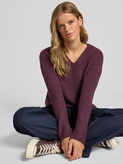 Vrouwenmodel draagt Regular Fit Pullover met V-hals model 'CAMILLA' van ONLY in bordeauxrood, grof gebreid, dames pullover, frontale opname van het hele lichaam.
