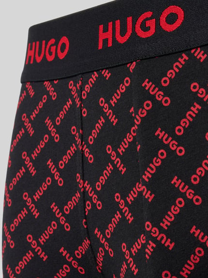 Produktfoto, schwarze Trunks aus Baumwoll-Mix im 3er-Pack von HUGO mit rotem HUGO-Logo-Alloverprint, Kontext: Herren Pant & Trunk von HUGO