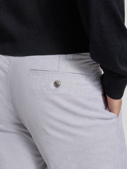 Mężczyznamodel nosi Stoffhose mit französischen Eingrifftaschen von MCNEAL, jasnoszary odcień, bawełna z elastanem, zbliżenie na kieszeń z tyłu, detailaufnahme.