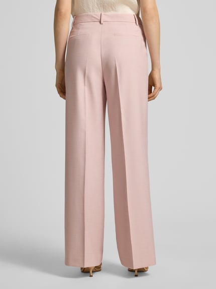 Frauenmodel trägt Hose aus Viskose-Mix mit Bügelfalten von More & More in zartem Rosa, Wide Leg, Bund und Eingrifftaschen, Ganzkörperansicht Rückansicht.