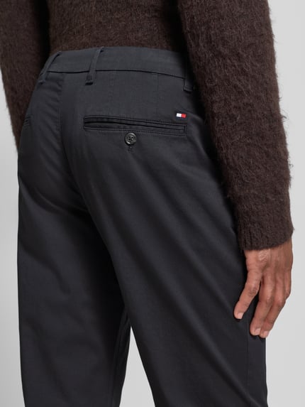 Männermodel draagt Regular Fit Chino uit katoenmix model 'DENTON' van Tommy Hilfiger met all-over motief, detailopname rugzijde.