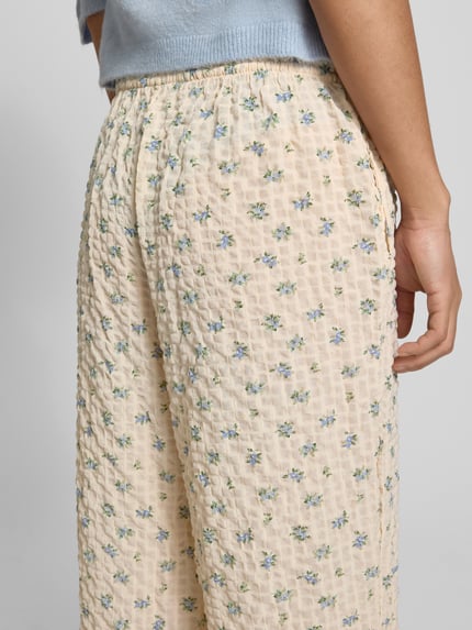 Frauenmodel trägt Wide Leg Pull-on-Hose aus Seersucker mit Kordelzug von REVIEW, Elastischer-Material-Mix, Blumenmuster, Nahaufnahme Oberschenkel.