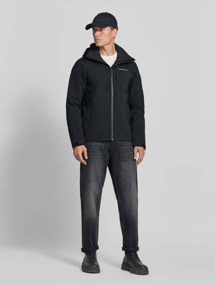 Mannelijk model draagt zwarte jack met capuchon Model 'Maroon' van Peak Performance, regular fit, labelstitching, ritssluiting, Ruglengte bij maat M 75 cm, schouderbreedte 47 cm, borstwijdte 57 cm, mouwlengte 69 cm, Ganzkörperansicht van voren.