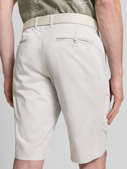 Männermodel trägt Bermudas aus Light Baumwolle mit Gürtel von Christian Berg Men, helle Farbe, Regular-Fit, Eingrifftaschen, Gesäßtaschen, Ganzkörperansicht Rückansicht. Bundweite bei Größe 50: 47 cm, Innenbeinlänge bei Größe 50: 28 cm.