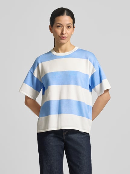 Frauenmodel trägt Relaxed Fit Shirt aus Viskose-Mix Modell 'LULS' von ICHI mit breiten blauen und weißen Streifen, Rundhalsausschnitt, Überschnittene Schultern, Ganzkörperansicht von vorne.