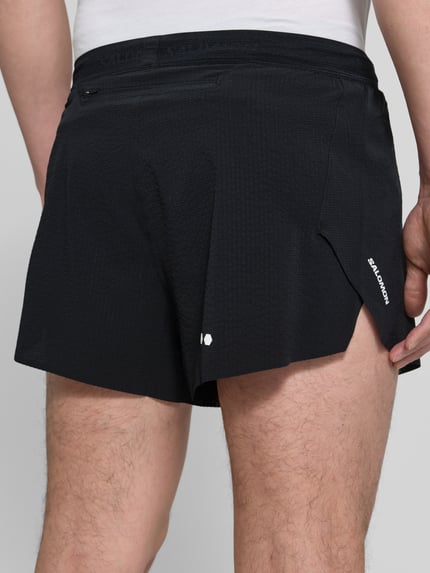 Männermodel trägt Shorts mit elastischem Bund Modell 'SENSE AERO' von Salomon aus schwarzem Material-Mix mit Stretch-Anteil, Regular-Fit, Ganzkörperansicht Rückansicht.