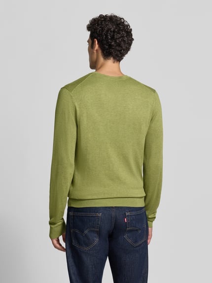 Männermodel trägt Strickpullover mit geripptem Rundhalsausschnitt von MCNEAL in Grün, taillierte Passform, Ganzkörperansicht Rückansicht.