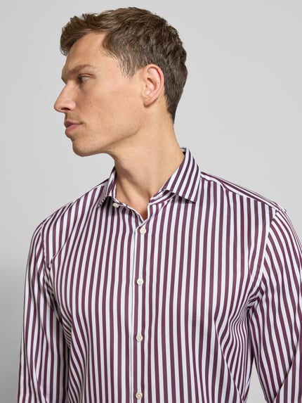 Männermodel trägt Slim Fit Business Hemd aus Baumwolle mit Haikragen von Jake*s, weiß-bordeaux gestreift, Nahaufnahme Oberkörper.
