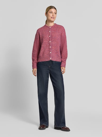 Frauenmodel trägt Relaxed Fit Strickjacke mit Woll-Anteil Modell 'Belablue' von ICHI in Pink, Knopfleiste, Jeans, Ganzkörperansicht von vorne. Elastischer Material-Mix, Rundhalsausschnitt, gerippte Bündchen, langärmlig, Damen Strickjacke.