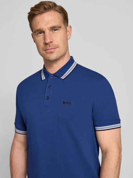 Männermodel trägt Regular Fit Poloshirt aus reiner Baumwolle Modell 'PADDY' von BOSS Green, unifarben, Nahaufnahme Oberkörper.