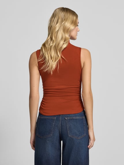 Modelka kobieca nosi Top mit Stehkragen und Raffungen od Gina Tricot, kolor rdzawy, bawełna z domieszką modalu, krój slim fit, marszczenia, długość tyłu w rozmiarze S: 56 cm, pełny widok sylwetki od tyłu