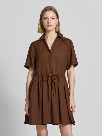 Kobiece model prezentuje Ausgestelltes Freizeitkleid aus reinem Leinen od Tommy Hilfiger, efekt: jednolity kolor, krój: rozkloszowana, dekolt w serek, kołnierzyk koszulowy, krótki rękaw, długość mini, wyhaftowane logo, materiał: len, całkowity widok z przodu