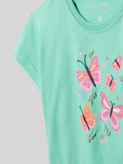 Mädchen trägt T-Shirt mit Stitching und Rundhalsausschnitt von Blue Seven, reine Baumwolle, Regular Fit, Nahaufnahme Oberkörper.